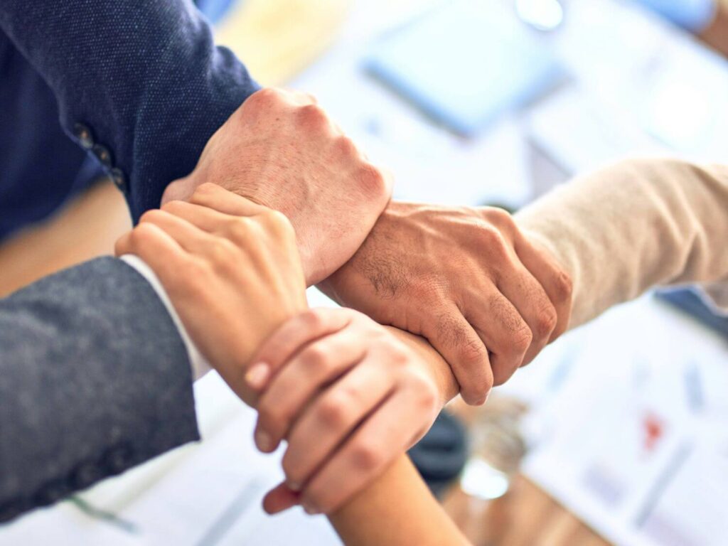 hands in a square of a charity team
